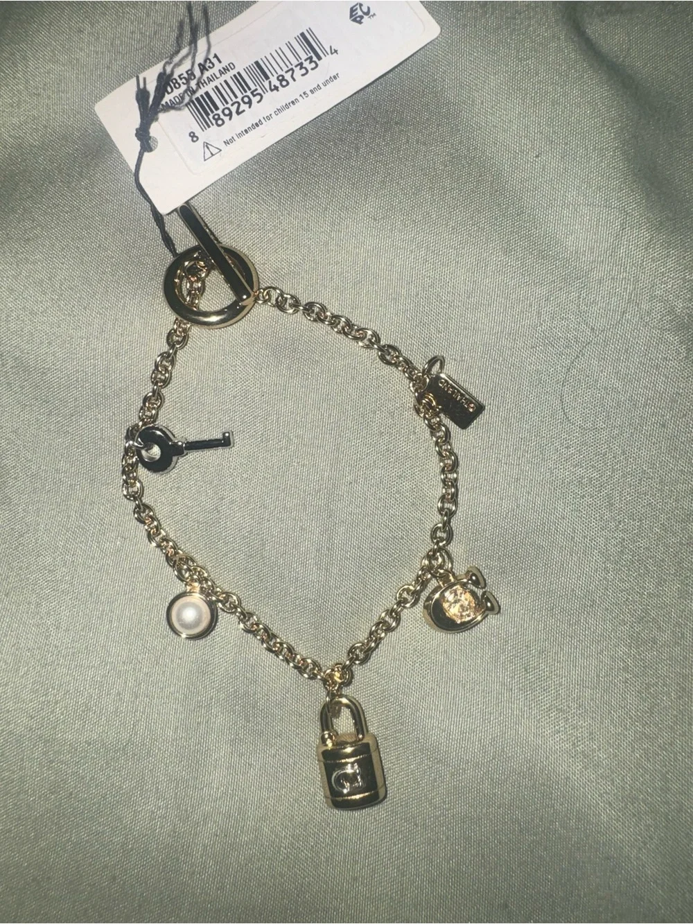 Coach Gold tone Charm Bracelet with Padlock, Key and Pearl Accents CD855 A31